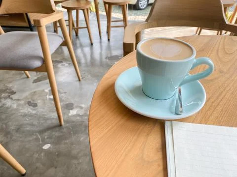 Study and work at the cafe. a cup coffee with an open book on the wooden table Stock Photos