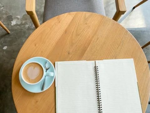 Study and work at the cafe. a cup coffee with an open book on the wooden table Stock Photos