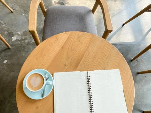 Study and work at the cafe. a cup coffee with an open book on the wooden table Stock Photos