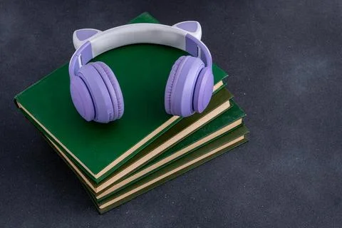 Study background Wireless Headphones with Cat Ears on Stack of Hardcover Books Stock-Fotos