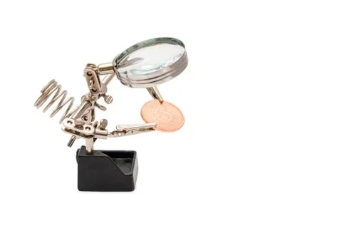 Study Bitcoins clamped jaws, through a magnifying glass, isolated on white ba Foto stock