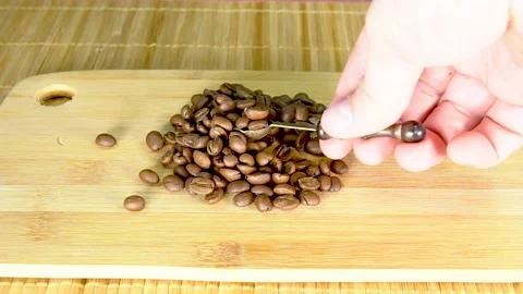 Study of coffee beans with a magnifying glass or a magnifying glass on the board Stock Footage 131474524
