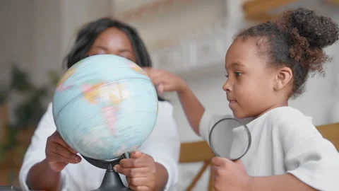 Study geography and have fun, little girl and mother dreaming about traveling. Stock Footage 344876311