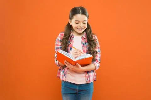 Study language. Making notes. Child doing homework writing in workbook. Girl Stock Photos