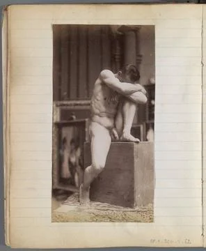 Study of a male nude model, sitting on a pied feature with a knee up and h... Stock Photos