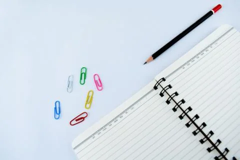 Study materials containing a black pencil,a notebook and some scattered paper Foto stock