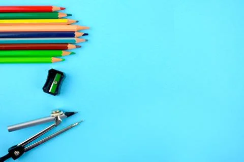 Study materials like pencil,sharpener,pencil compass arranged on a paper back Stock Photos
