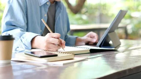 Study online class, Student man hand writing on notebook while learning onlin Stock Photos