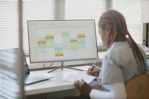 Studying a Calendar on Computer Screen in Modern Office Stock Photos