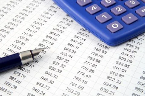 Studying financial numbers on a printed spreadsheet. Photos