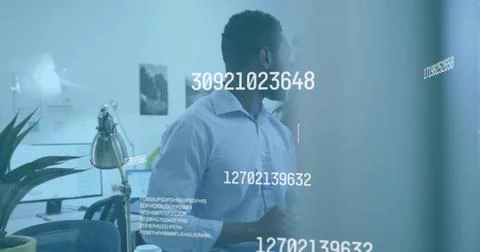 Studying man wearing light button-down shirt scanning numeric data on glass 스톡 사진