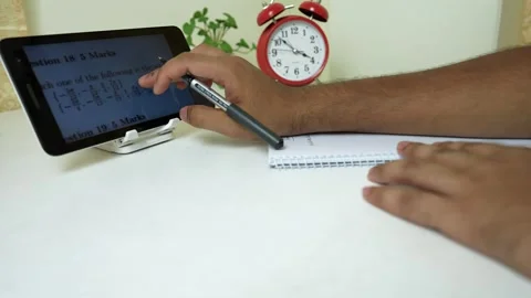 Studying Math on Tablet with Notebook and Clock Stock Footage 318578347