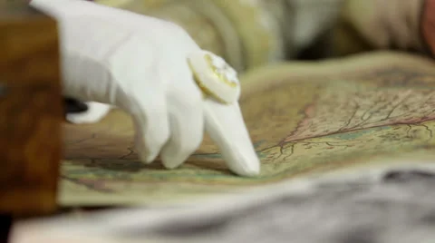 Studying an old map while following a road with his finger Video stock 33035570