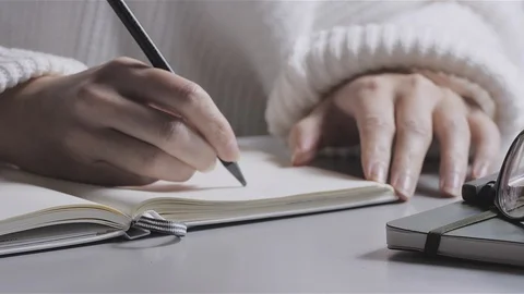 Studying or Working from home A Young Woman or Teenage Girl Writing in notebook Stock Footage 99396791