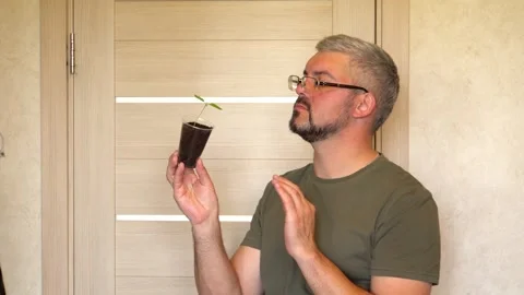 Studying a plant in a plastic cup 4K Video stock 274402641