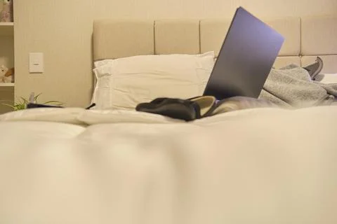 Studying remotely in bed using laptop for distance learning Fotos Stock