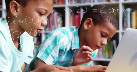 Studying two boys solving math problems in study room, with laptop and Stock Photos