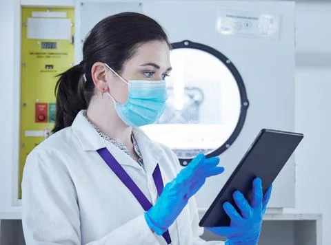 Studying to upkeep her knowledge. a young woman working in a lab using a digital Stock Photos