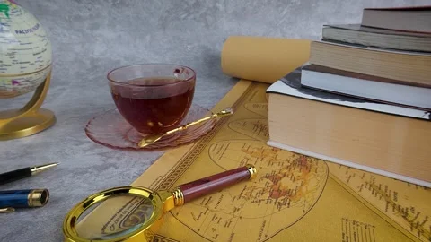 Studying World Map with Books and Tea Still Life Stock Footage 313373720