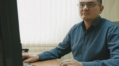 Stuff in office: portrait of man in glasses working at computer, close up Stock Footage 68044798