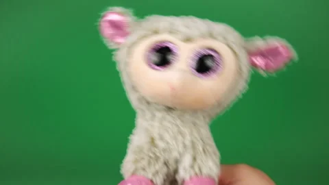 Stuffed and fluffy plush toy sheep playing and dancing on a green background. Stock Footage 272683559