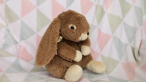Stuffed and fluffy plush toy rabbit falls on a soft baby blanket. Slow motion. Vídeo Stock 273478519