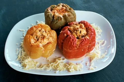 Stuffed bell peppers. Three cooked stuffed peppers on a white plate. Deliciou Stock Photos
