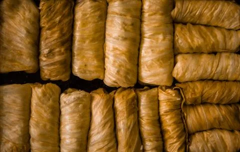 Stuffed cabbage rolls in a baking tray on a black background. Selective focus. Stock Photos