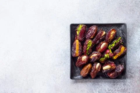 Stuffed dates with nuts and candied fruit filling on a stone. Stock Photos