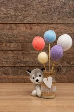 Stuffed dog holding a jar with thread balls Stock Photos
