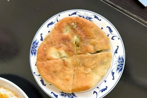 Stuffed flatbread on a decorative plate. Stock-Fotos