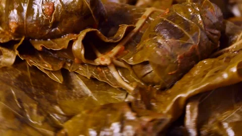 Stuffed grape leaves with rice and meat rotates on a board Video stock 248322861