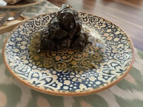 Stuffed grape leaves served on a patterned plate for a Mediterranean meal c.. Stock Photos