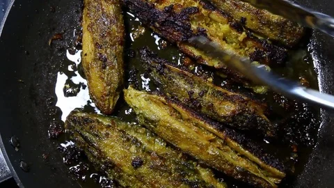 Stuffed Karela or stuffed Bitter gourd shallow frying in a pan Stock Footage