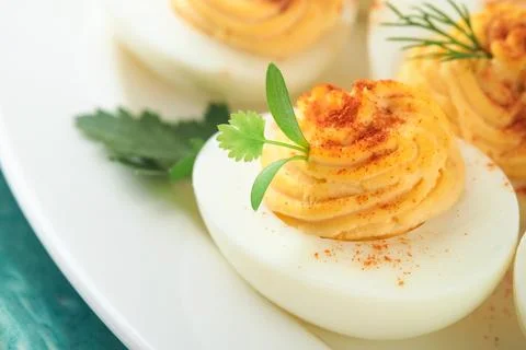 Stuffed or deviled eggs with paprika and parsley on blue plate for easter t.. 스톡 사진