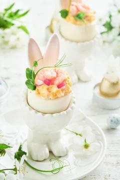 Stuffed or deviled eggs with yolk, shrimp, pea microgreens with paprika in ra 스톡 사진