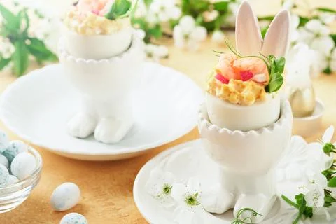 Stuffed or deviled eggs with yolk, shrimp, pea microgreens with paprika in ra Stock Photos