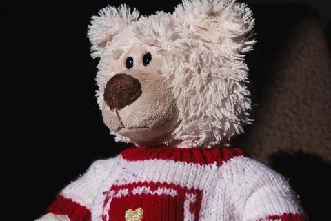 A stuffed teddy bear with a red and white striped sweater on a white background, Stock Photos