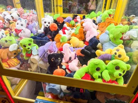 Stuffed toys inside a claw machine. Childhood, leisure, play and amusement in Stockfoto's