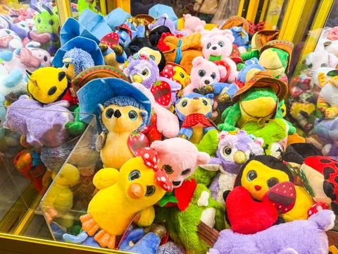 Stuffed toys inside a claw machine. Childhood, leisure, play and amusement in Stock Photos