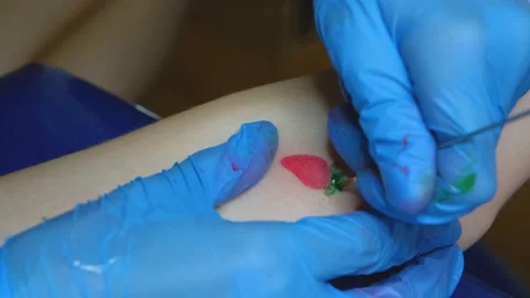 Stuffing a tattoo with a needle. The process of stuffing a tattoo close-up. Hand Stock Footage 214495047