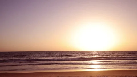 A stunning 4K time-lapse of a vibrant beach sunset with silhouettes of people. Stock Footage 341545995
