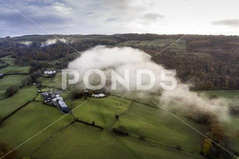 Stunning aerial drone landscape image from in the clouds looking down on hill Stock Photos
