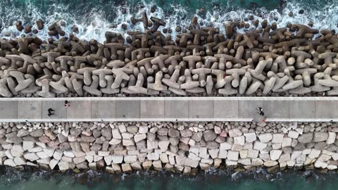 A stunning aerial drone view of waves crashing against rocks Stock Footage 296176277