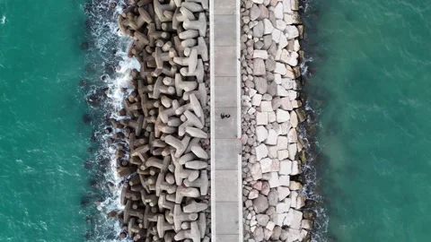 A stunning aerial drone view of waves crashing against rocks Stock Footage 296176631