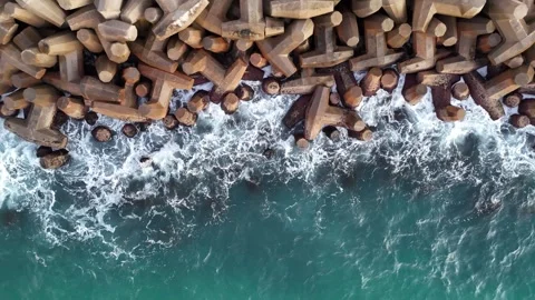 A stunning aerial drone view of waves crashing against rocks Stock Footage 296176906