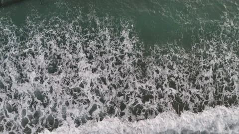A stunning aerial drone view of waves crashing against rocks Stock Footage 296177300