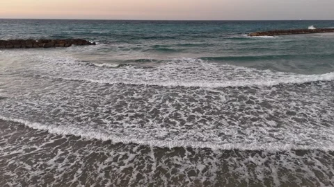 A stunning aerial drone view of waves crashing against rocks Stock Footage 296177680