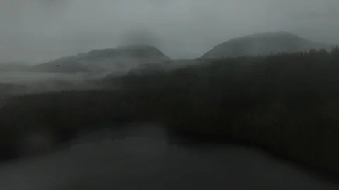 Stunning aerial shot of eagle flying away with cloud covered mountains in mist Stock Footage 104923672