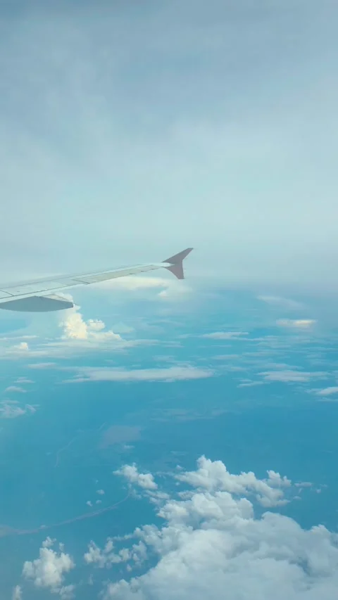 Stunning aerial view from airplane window featuring wing clouds and blue sk.. Stock Footage 333839088